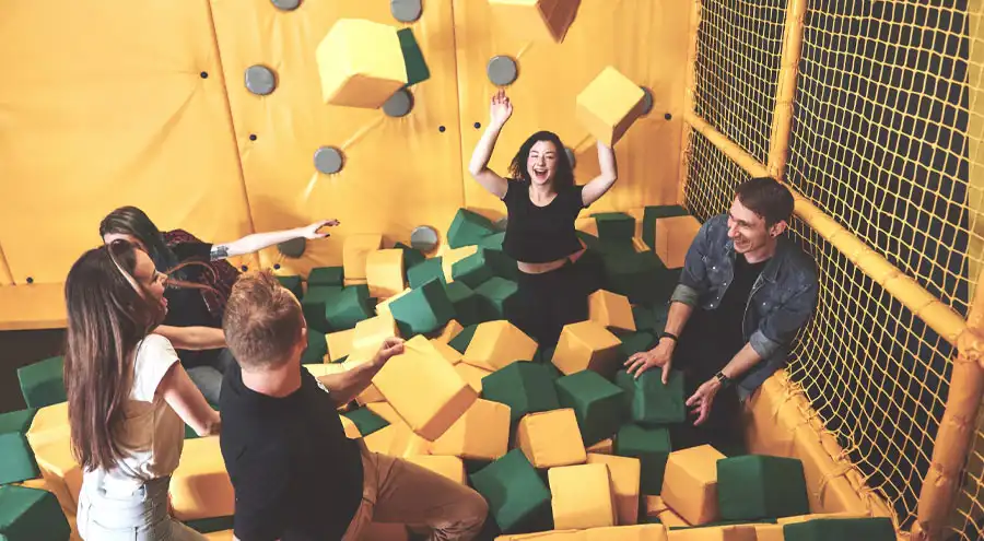 a group of people playing in an indoor foam pit