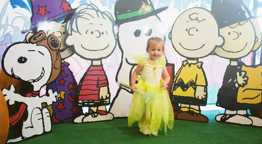a child dressed as a fairy poses at a Halloween photo-op