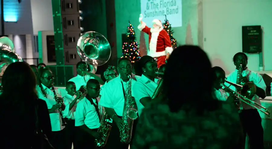 a marching band performs with Santa at the Christmas Near The Beach event in Hollywood